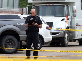 Police investigate the area where a man was found dead on the street on 81 ave and Calgary Trail in Edmonton, Alberta on July 20, 2014.  Perry Mah/Edmonton Sun/QMI Agency