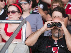 A football fan focuses in on the action during the RedBlacks home opener Friday night. A total of almost 40,000 fans were at TD Place this weekend for the RedBlacks and Fury games. Chris Roussakis/Ottawa Sun/QMI Agency