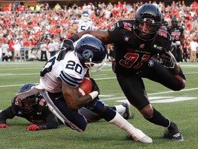 Argos running back Steve Slaton is tackled by a RedBlacks defender last month. (REUTERS)