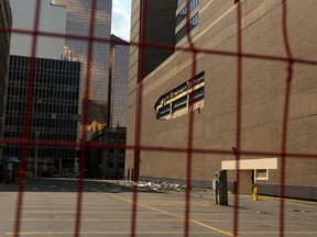 A fence surrounds an area around the Westin Hotel yesterday, where part of the exterior wall collapsed on to the alley in Edmonton on Sunday. (PERRY MAH/Edmonton Sun)