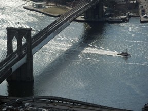 A tug boat passes under the Brooklyn Bridge in New York. (AFP PHOTO/Stan HONDA)