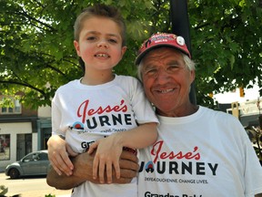 Bob Facca stands next to grandson Louie Facca at Covent Garden Market in London, Ont. July 22, 2014. Bob Facca, in the midst of a 4,000 km fundraising walk supporting Duchenne muscular dystrophy research, stopped in London July 22 for a fundraising barbecue downtown. CHRIS MONTANINI\LONDONER\QMI AGENCY.