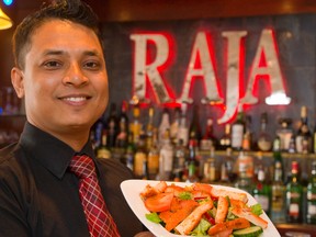 Razaul Chowdhury, of Raja Fine Indian Cuisine on Clarence St., shows off a lunch favourite, Tandoori chicken salad. His brother, Zahirul, owns the restaurant. (Mike Hensen, The London Free Press)