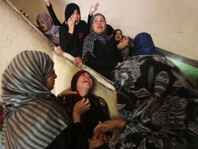 Relatives of Palestinian Islamic Jihad militant Abduallah El-Buhasi, who medics said was killed in an Israeli air strike, mourn during his funeral in Deir El-Balah in the central Gaza Strip July 22, 2014. (Reuters)