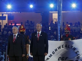 Lord Robert Smith, centre, takes part in the flag hand over ceremony with Lord Provost of Glasgow Bob Winter, left, at the closing ceremonies of the New Delhi Commonwealth Games in 2010. (Reuters)