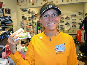 Run For Your Life owner Terri Biloski holds protein bars while at her store Tuesday where they are sponsoring a 30-day Healthy Eating Challenge. Participants will receive support and nutritional advice during the month of August. 
DON BIGGS/TIMES-JOURNAL