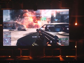 People are shown a Los Angeles street battle scene in the beta version of "Battlefield: Hardline" at the Electronic Arts (EA) World Premiere: E3 2014 Preview press conference at the Shrine Auditorium in Los Angeles, June 9, 2014. REUTERS/David McNew