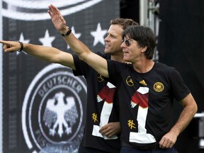 Germany's head coach Joachim Loew and team manager Oliver Bierhoff (L) applaud fans during celebrations to mark the team's 2014 Brazil World Cup victory, at a 'fan mile' public viewing zone in Berlin July 15, 2014. (REUTERS)