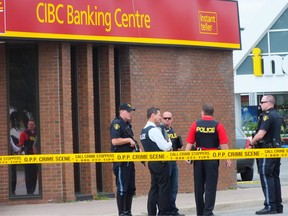 Police stand outside of the CIBC on Petrolia Line after a bank robbery on Wednesday afternoon. No one was injured and police are searching for a suspect. BRENT BOLES / THE OBSERVER / QMI AGENCY