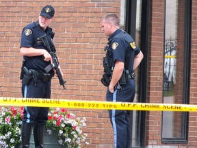 Heavily armed police officers stand outside of a bank in Petrolia Wednesday afternoon, after a bank robbery. The suspect carried what police say appeared to be a handgun. No one was injured. BRENT BOLES / THE OBSERVER / QMI AGENCY
