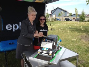 Edmonton Public Library CEO Linda Cook, left, cuts a cake with community librarian Laura Young at A. Blair McPherson school Wednesday to celebrate the library's first EPL2Go literacy van. Kevin Maimann/Edmonton Sun