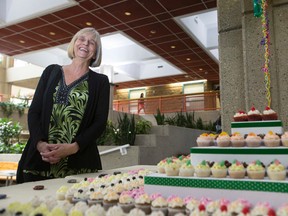 Volunteer Liz Kennedy poses for a photo beside cupcakes at a celebration of 35 years of the EPS Victims Services Unit at Edmonton Police Service Headquarters in Edmonton, Alta., on Wednesday, July 23, 2014. A proclamation of Victims Services Day was read by Edmonton Coun. Mike Nickel at the event. Ian Kucerak/Edmonton Sun/QMI Agency