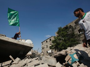 A Palestinian boy places a Hamas flag atop the rubble of a house which police said was destroyed in an Israeli air strike in the northern Gaza Strip July 9, 2014.
REUTERS/Mohammed Salem