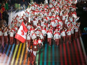 Edmonton's Susan Nattrass sports a kilt featuring the maple leaf tartan — followed by her teammates sporting matching pants — as she carries the Canadian flag during the opening ceremonies of the 20th Commonwealth Games in Glasgow, Scotland. (Reuters)