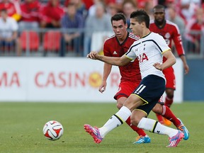 Tottenham Hotspur midfielder Erik Lamela (11) passes the ball against Toronto FC midfielder Daniel Lovitz (35) during the first half at BMO Field on July 23, 2014. (JOHN E. SOKOLOWSKI/USA TODAY Sports)