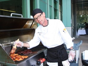 JOHN LAPPA/THE SUDBURY STAR
Mark Burton, of Rock Garden Cafe, cooks meat and poultry on a barbecue at the Berry Festival Barbecue at the outdoor courtyard at Health Sciences North on Wednesday. The barbecue was held by the hospital and Marek Hospitality, which runs the cafe, to show their commitment to the 2014 Ontario Local Food Challenge. The event featured local food such as strawberry and blueberry pies, jams and Ontario chicken and bison. The challenge is a provincial initiative to encourage institutions to have more local food in their menus.