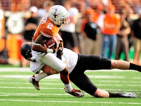 Caleb Lavey #45 of the Oklahoma State Cowboys brings down Kendall Sanders #2 of the Texas Longhorns during a game at Darrell K Royal-Texas Memorial Stadium on November 16, 2013 in Austin, Texas. (Stacy Revere/Getty Images/AFP)