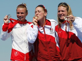 England's Jodie Stimpson (center) celebrates with her gold medal with silver medal winner Kirsten Sweetland (left) of Canada and Victoria Holland of England after the women's triathlon race at the 2014 Commonwealth Games in Glasgow, Scotland, July 24, 2014. (REUTERS/Russell Cheyne)