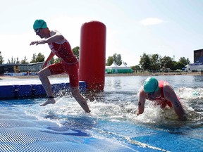 England's Jonathan Brownlee (left) and and his brother Alistair Brownlee finish the swim portion of the men's triathlon race at the 2014 Commonwealth Games in Glasgow, Scotland, July 24, 2014. (REUTERS/Russell Cheyne)