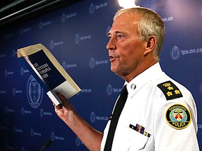 Toronto Police Chief Bill Blair holds a copy of retired Supreme Court justice Frank Iacobucci's report on the use of force by police officers dealing with people in distress on July 24, 2014. (Michael Peake/Toronto Sun)