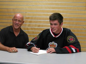 The Sarnia Legionnaires have signed a blue chip prospect. Here, head coach Dan Rose looks on while flashy rearguard Cameron Clarke puts his signature to paper. (Submitted photo courtesy of Anne Tigwell)