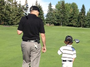 The old guy gets some advice from the young gun as they head toward their second shots on the third hole. - Photo by Jane Watson-Montgomery