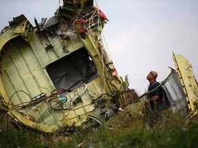 A Malaysian air crash investigator inspects the crash site of Malaysia Airlines Flight MH17, near the village of Hrabove (Grabovo), Donetsk region July 22, 2014. (REUTERS/Maxim Zmeyev)