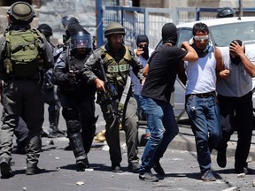 Undercover Israeli policemen and uniformed policemen detain a Palestinian during clashes in the East Jerusalem neighbourhood of Wadi al-Joz during a protest against the Israeli offensive on Gaza. REUTERS/Ammar Awad