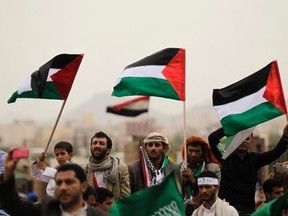 People wave Palestinian flags during a rally to show solidarity to Gaza, in Sanaa July 25, 2014. Gaza officials said Israeli strikes killed 27 people on Friday. REUTERS/Khaled Abdullah