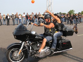 Tossing a water balloon over a bar and then catching it again while on a moving motorcycle was one of the games played at Fort Henry during the Harley Owners Group weekend rally. FRI., JULY 25, 2014 KINGSTON, ONT. MICHAEL LEA\THE WHIG STANDARD\QMI AGENCY
