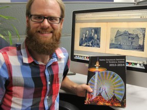 SCITS teacher Caleb Courtney shows off a scanned 1902 yearbook and a hard copy of the school's 2013-2014 yearbook. Copies of SCITS yearbooks are now available online thanks in part to the Ontario Genealogical Society's Lambton branch. BARBARA SIMPSON/THE OBSERVER/QMI AGENCY