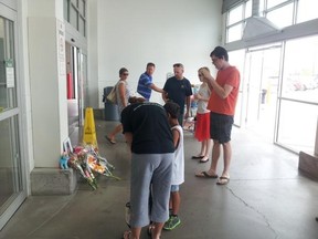 Costco customers look at a tribute set up for a six-year-old girl struck by a vehicle Friday in the store's entrance. The crash injured six people, three of them critically. JENNIFER O'BRIEN / THE LONDON FREE PRESS