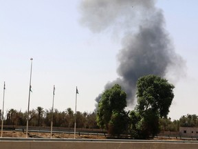 Smoke rises over the Airport Road area after heavy fighting between rival militias broke out near the airport in Tripoli July 25, 2014. Heavy black smoke rose over southern Tripoli on Thursday after rival militias exchanged artillery and rocket fire in a battle over the Libyan capital's airport that has killed around 50 people in nearly a fortnight of fighting. REUTERS/Hani Amara