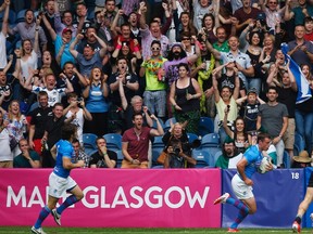 Fans cheer as Scotland's Lee Jones (R) scores a try against New Zealand during men's Rugby Sevens at the 2014 Commonwealth Games in Glasgow, Scotland, July 26, 2014. (REUTERS/Jim Young)