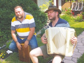 Paul Galea (left) slaps out percussion from his cajón box-shaped drum with a hole in it to original melodic tunes performed by Chris the Accordion Guy (right), on one of his 120 bass piano accordions during Saturday’s Artful Garden Tour at Linda and Mitch Omichinski’s in rural Portage. Ted provides details about an upcoming Outdoor Summer Folk Fest Concert at the same location, on Wednesday night, Aug. 13 from 7-10 p.m.