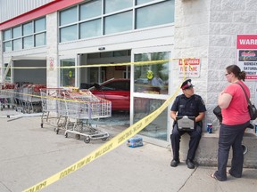 A witness gives a statement to police after five shoppers and the driver  were sent to hospital after a car crashed through the entrance of the Costco Wholesale store on Wellington Road  in London, Ontario on Friday, July 25, 2014. DEREK RUTTAN/QMI AGENCY