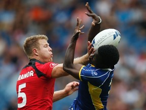 Canada's Conor Trainor (L) and Barbados' Dario Stoute battle for the ball during men's Rugby Sevens at the 2014 Commonwealth Games in Glasgow, Scotland, July 26, 2014. REUTERS/Jim Young (BRITAIN - Tags: SPORT RUGBY)