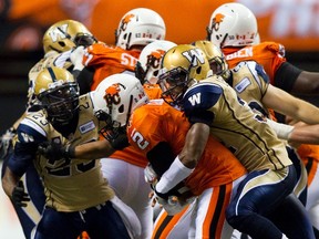 Lions QB Kevin Glenn gets sacked by Winnipeg Blue Bombers DB Maurice Leggett on Friday night. (BEN NELMS/Reuters)