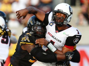 Ottawa RedBlacks quarterback Henry Burris gets hit hard by a Tiger-Cats player during their CFL game on Saturday night at McMaster University. (CRAIG ROBERTSON/TORONTO SUN)