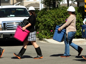 A family leaves with their belongings after a multi-million fire in the Park Place South Hamptons at 1520 Hammond Gate in Edmonton Alta. The fire was started on Monday, July 21, 2014, by a cigarette butt in a planter. Residents were allowed to book a time to get into their suites on Thursday July 24, 2014. (Perry Mah/Edmonton Sun)