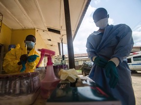 Medical staff put on protective gear in Kenema government hospital before taking a sample from a suspected Ebola patient in Kenema, July 10, 2014. REUTERS/Tommy Trenchard