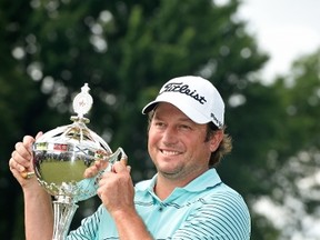 Tim Clark of South Africa holds the trophy after winning the RBC Canadian Open at the Royal Montreal Golf Club on July 27, 2014 in Montreal, Quebec, Canada. (Charles Laberge/Getty Images/AFP)