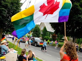 A supporter waves a flag as the annual Pride London parade makes it's way down Queens Avenue in London, Ontario on Sunday July 27, 2014.  Hundreds of men, women and children lined the sidewalks to watch as hundreds more supporters of the LGBT community walked, danced, and paraded their way to Victoria Park to cap off a week-long celebration.
CRAIG GLOVER/The London Free Press/QMI Agency