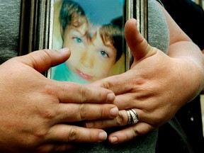 Crystal Pentecost holds a photo of her son Dawson as she speaks to the media while requesting the public's help in returning a necklace that was recently stolen, outside EPS headquarters in Edmonton Alta., on Tuesday July 22, 2014. The necklace holds the remains of her son Dawson, 9, who was killed in a February 10, 2013 plane crash. David Bloom/Edmonton Sun/ QMI Agency