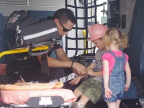 Ryan Byrne/For The Sudbury Star
Paramedic Larry Lambovitch checks children's pluses at the barbecue last Saturday.