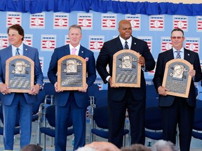 Inductees, from left, Bobby Cox, Tony La Russa, Tom Glavine, Frank Thomas, Greg Maddux and Joe Torre pose with their plaques at Clark Sports Center during the Baseball Hall of Fame induction ceremony on July 27, 2014 in Cooperstown, New York. (Jim McIsaac/Getty Images/AFP)