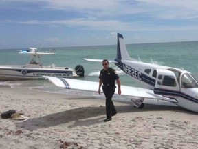 First responders respond at the scene of a single engine Piper Cherokee plane crash in this photo provided by the Sarasota County Sheriff's Office in Caspersen Beach in Venice, Florida July 27, 2014.  REUTERS/Sarasota County Sheriff's Office/Handout