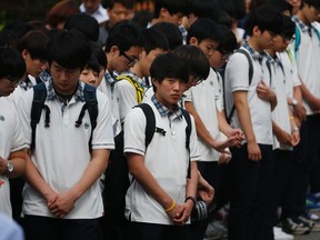 Students who survived the April 16 ferry disaster gather at the main gate as they make their way back to school in Ansan on June 25, 2014. (REUTERS/Kim Hong-Ji)
