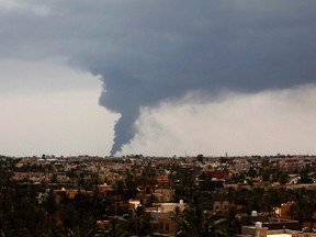 Plumes of smoke rise in the sky after a rocket hit a fuel storage tank near the airport road in Tripoli, during clashes between rival militias July 28, 2014.  REUTERS/Ismail Zitouny