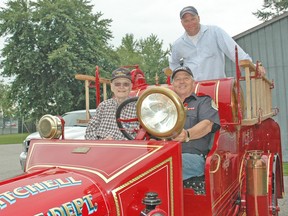 Gary Kersten (left), of Grosse Point, Michigan, his son Gary Jr., centre, and retired West Perth captain Bill Eidt (in driver’s seat) were all smiles when Kersten visited Mitchell on Saturday, July 19. Kersten is the former owner of the 1921 Model T Ford fire truck pictured here. His son Gary drove his 86-year-old father to Mitchell to enjoy one last ride and see it fully restored. KRISTINE JEAN/MITCHELL ADVOCATE